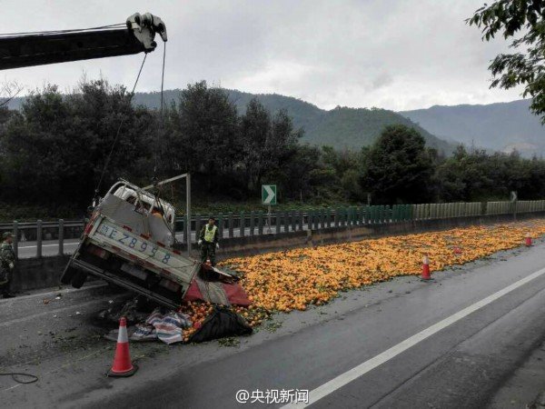 货车侧翻3吨橙子散落 交警群众一起救援