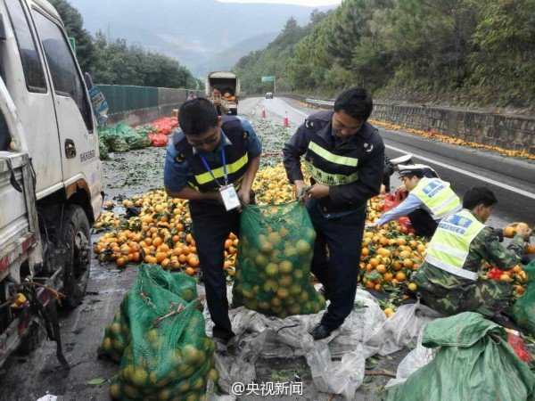 货车侧翻3吨橙子散落 交警群众一起救援