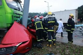 珍爱生命远离渣土,马自达轿车被拦腰截断,所幸女司机只受轻伤