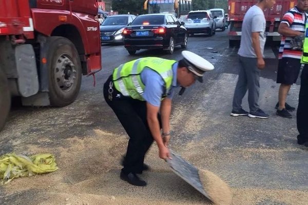 货车侧翻谷洒一地 交警化身“搬运工”
