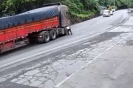 碰瓷大货车？路边抽烟男子突然冲上公路撞上货车车轮后倒地