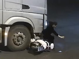 女子接听电话不带头盔 被货车撞翻险些被卷入车底