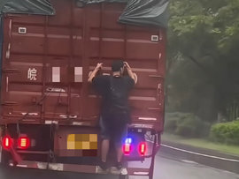 男子货车后搭顺风车 看似危险实则也不安全