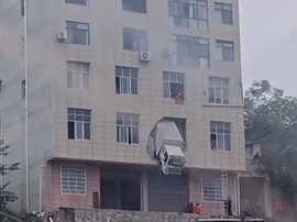 小货车撞破墙体冲进居民楼2楼 大半个车身悬空!