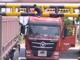 货车被卡限高杆 司机无奈用大锤砸扁车头脱困