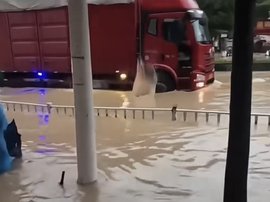 大车在积水道路上驶过 附近商户拿砖头直接砸？